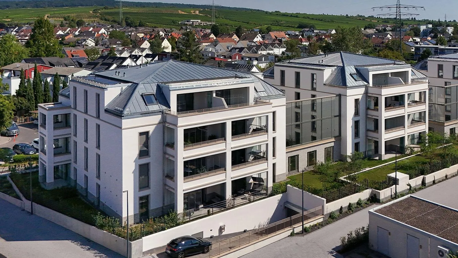 The new HelloStay apartment building in Eltville am Rhein with vineyards in the background
